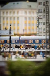 Detailed shot of a 1/64 scale diorama featuring a tiny train station with waiting passengers.