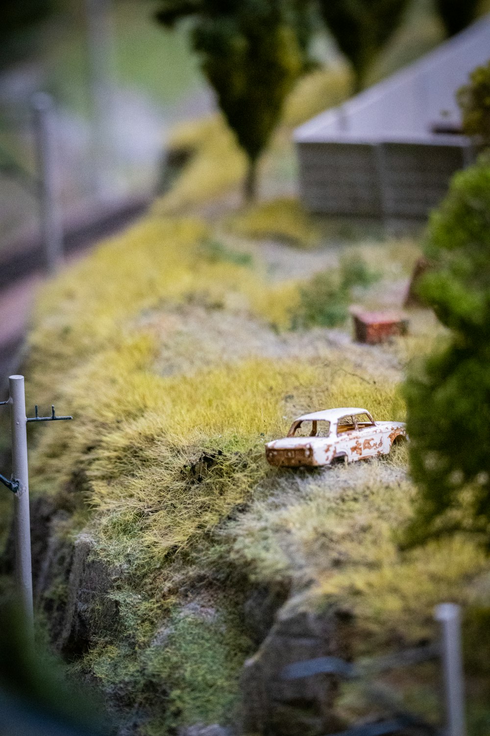 Un coche de juguete está estacionado en la ladera de una colina