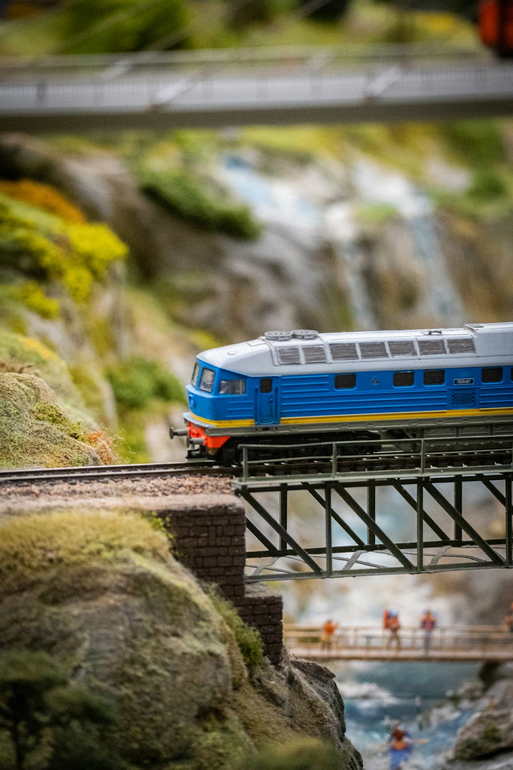 a blue and white train traveling over a bridge