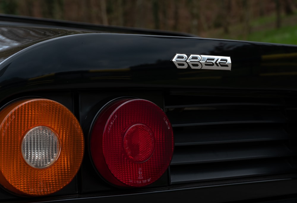 a close up of the tail lights of a black sports car