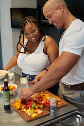 A warm photo of a smiling couple preparing a healthy meal together in a cozy kitchen.