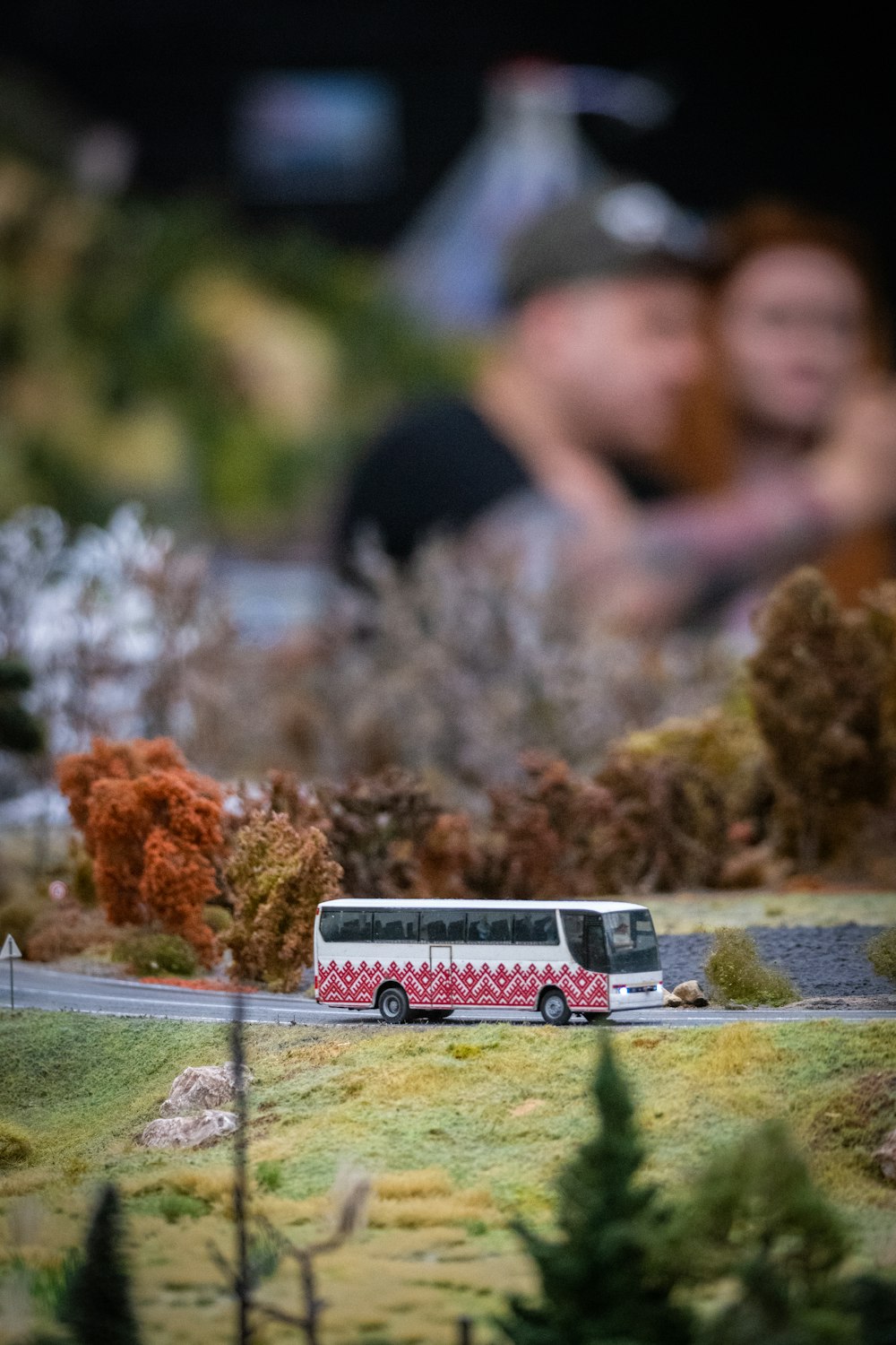 a model of a bus and a couple in the background