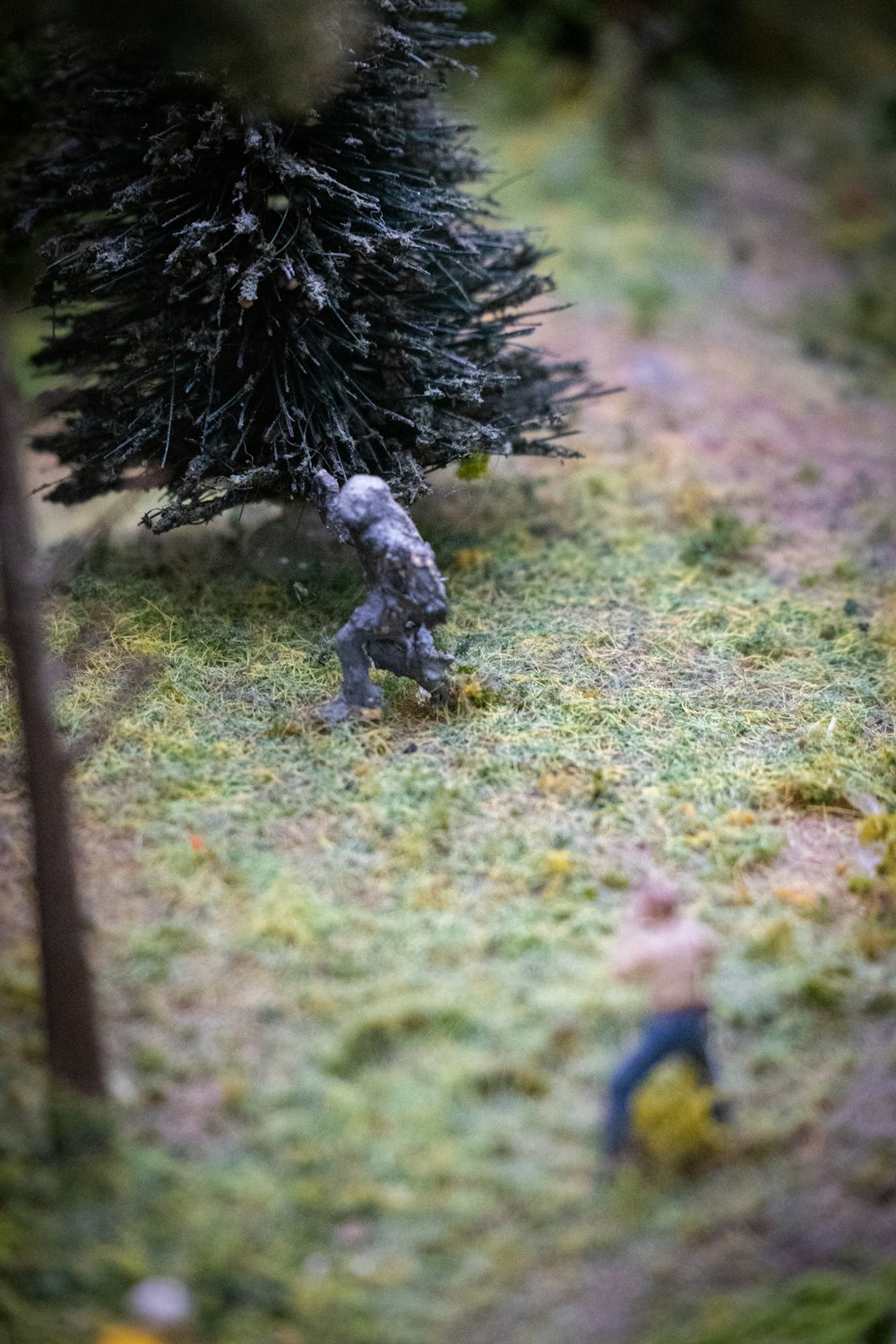 a toy soldier is in the grass next to a tree