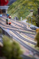 A detailed model train set with miniature landscapes and tiny figures in a cozy room.