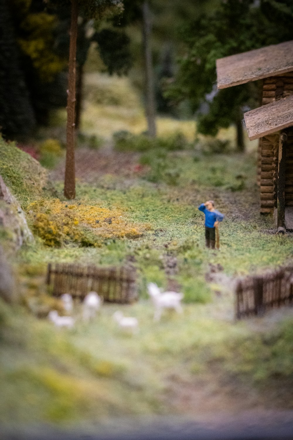 a miniature scene of a person standing in the grass
