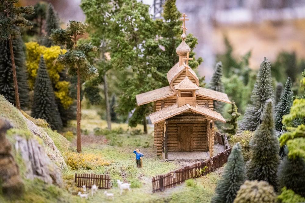 a model of a small wooden church surrounded by trees