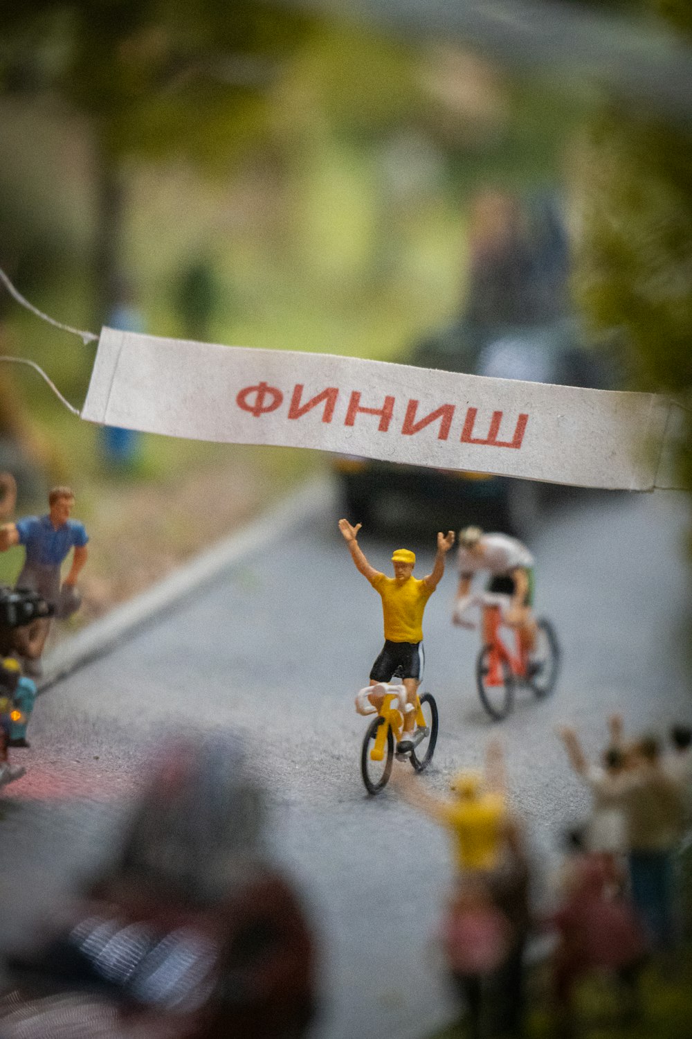 a group of toy people riding bikes down a road
