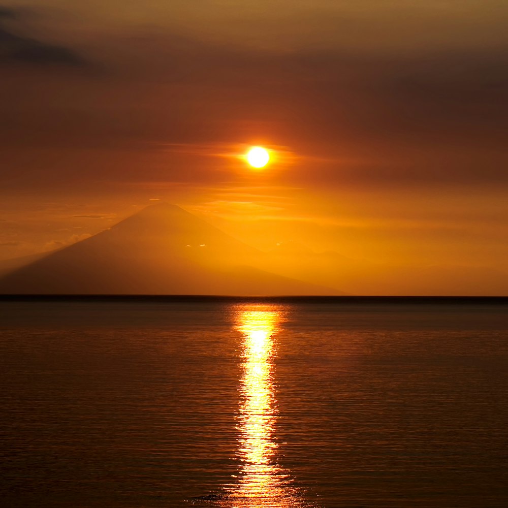 a large body of water with a mountain in the background