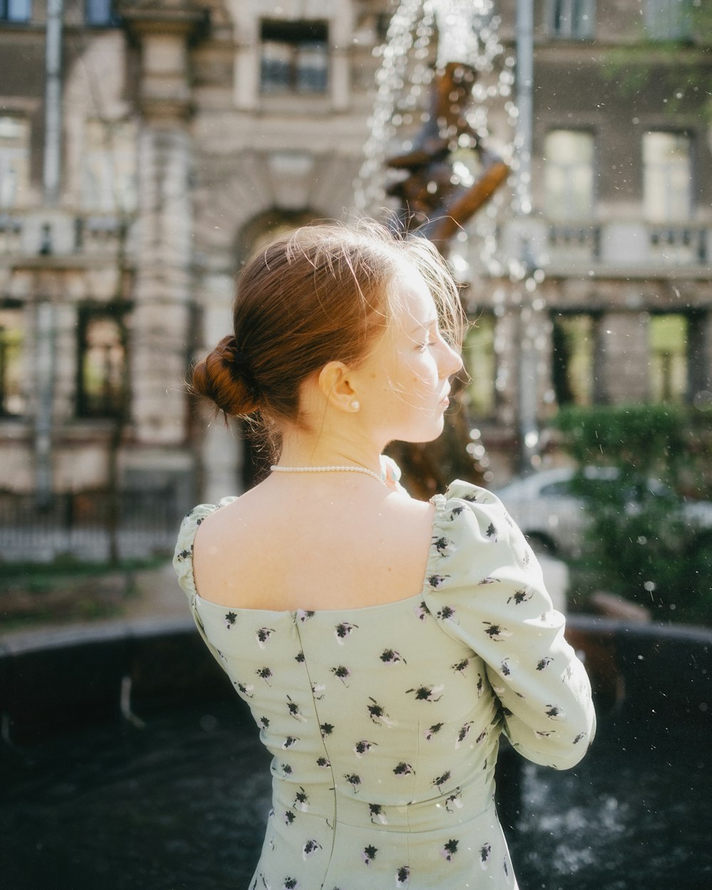 a woman standing in front of a fountain