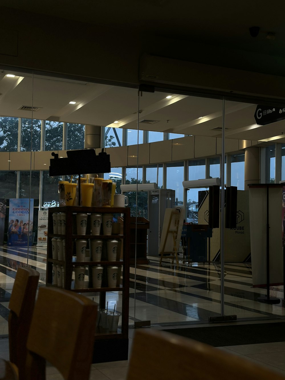 a coffee shop with chairs and tables in front of large windows