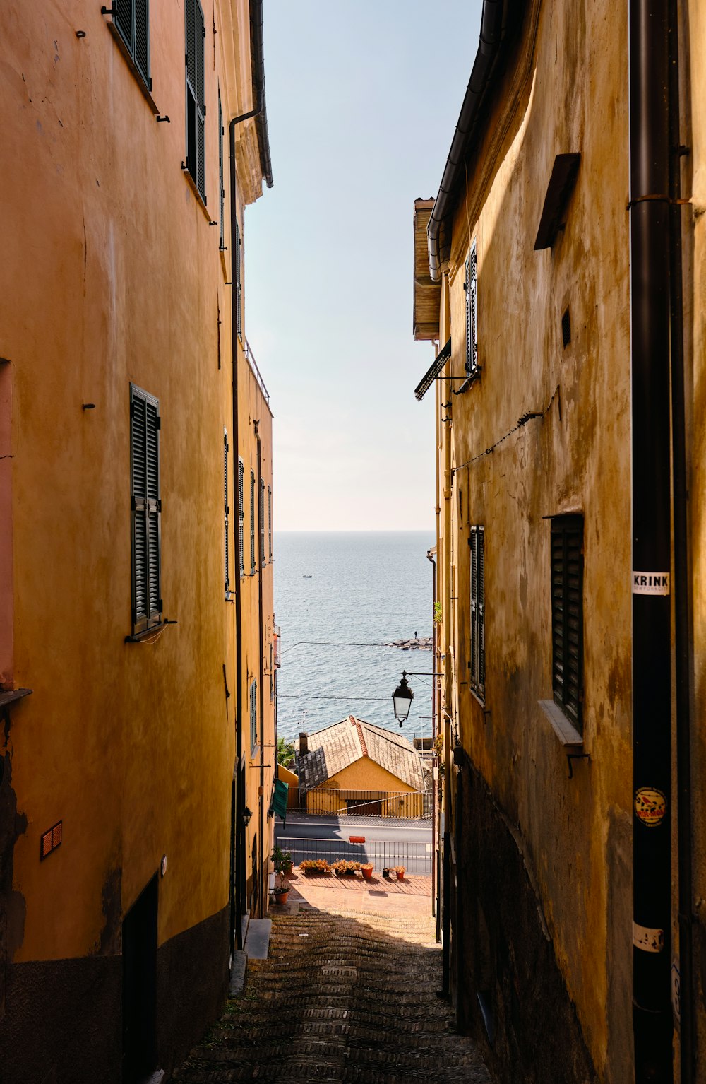 a narrow alley with a view of the ocean