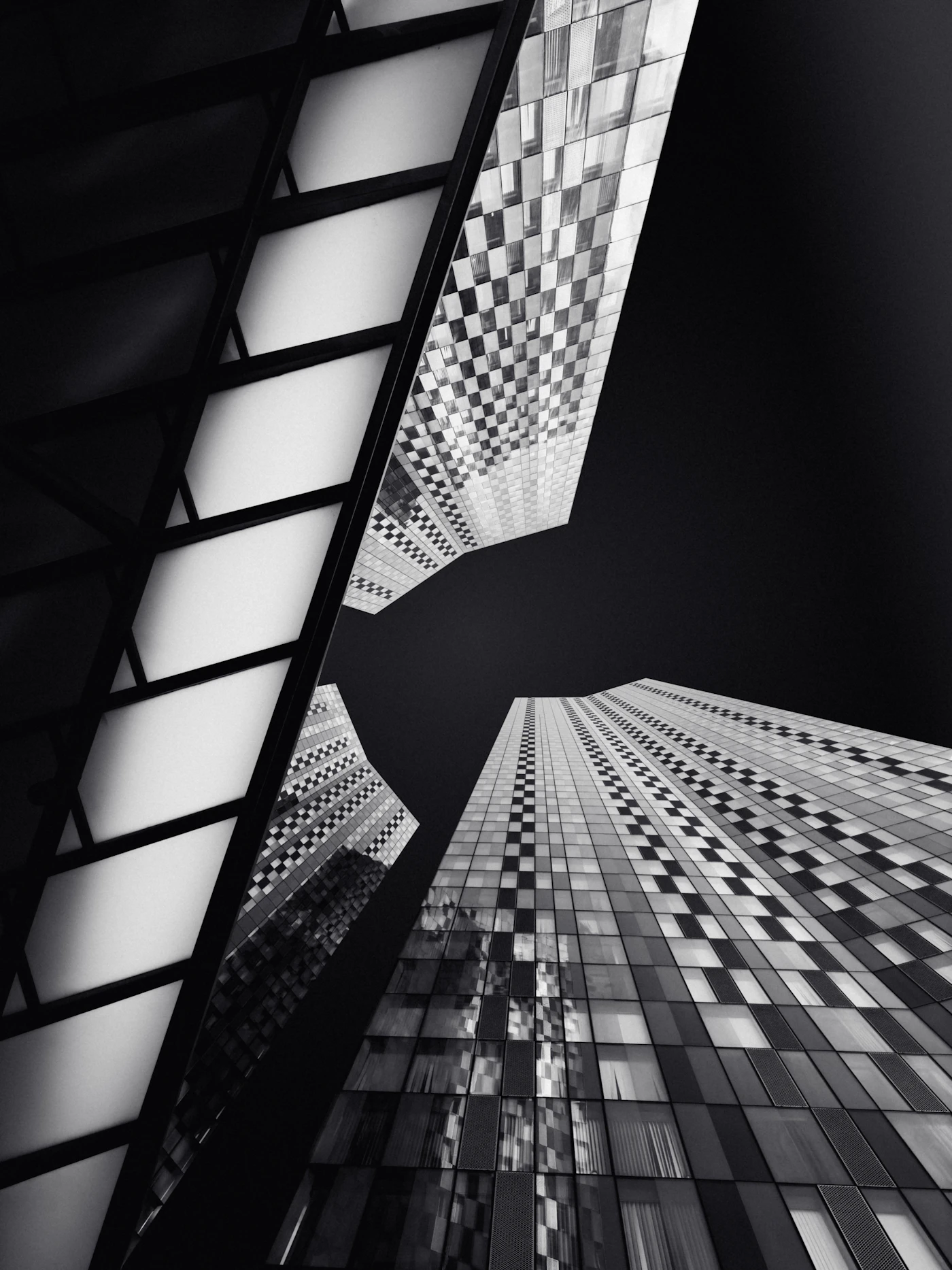 A glass tower rising into a pale sky