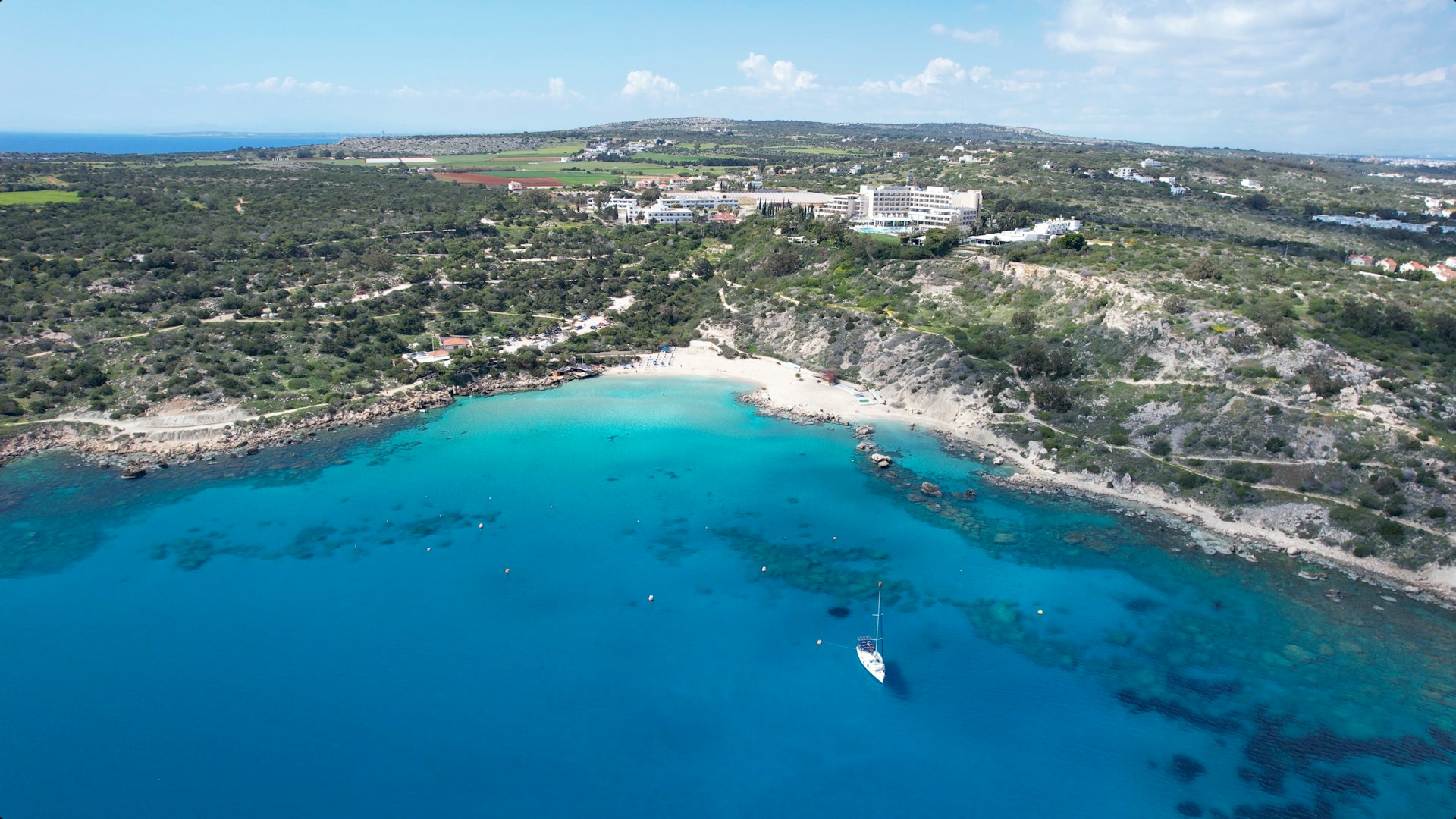 an aerial view of a beach with a boat in the water