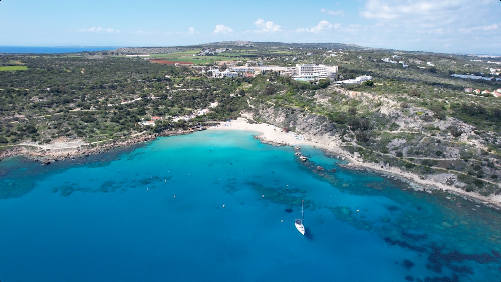 an aerial view of a beach with a boat in the water