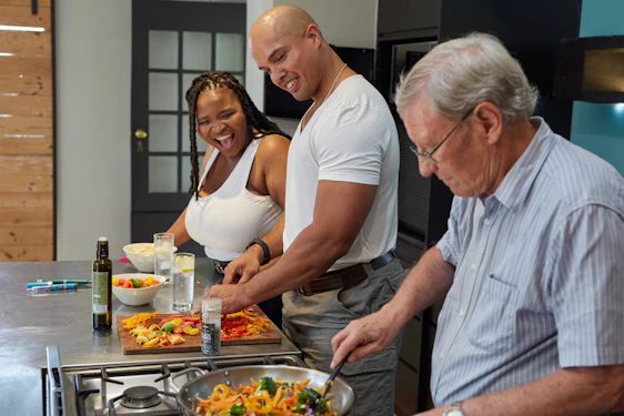 A cozy kitchen scene with a family cooking together, sharing smiles and laughter.