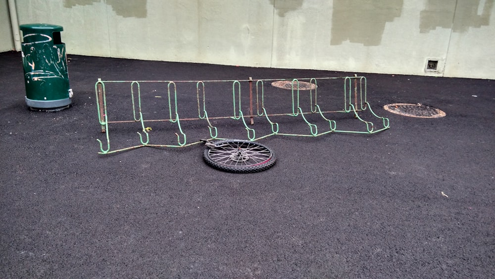 a bike tire sitting on the ground next to a fence