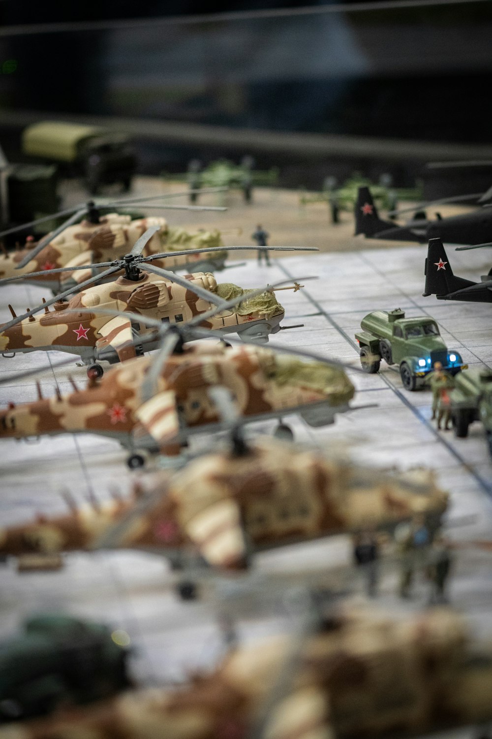 a group of toy army vehicles and helicopters on a table
