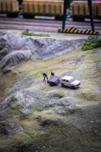 A powerful semi truck RC model hauling a trailer on a miniature highway setup.