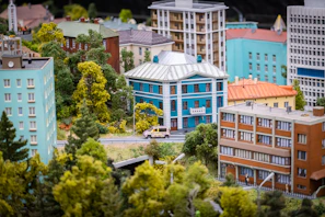 An urban cityscape model with skyscrapers, streets, and miniature vehicles made from blocks.