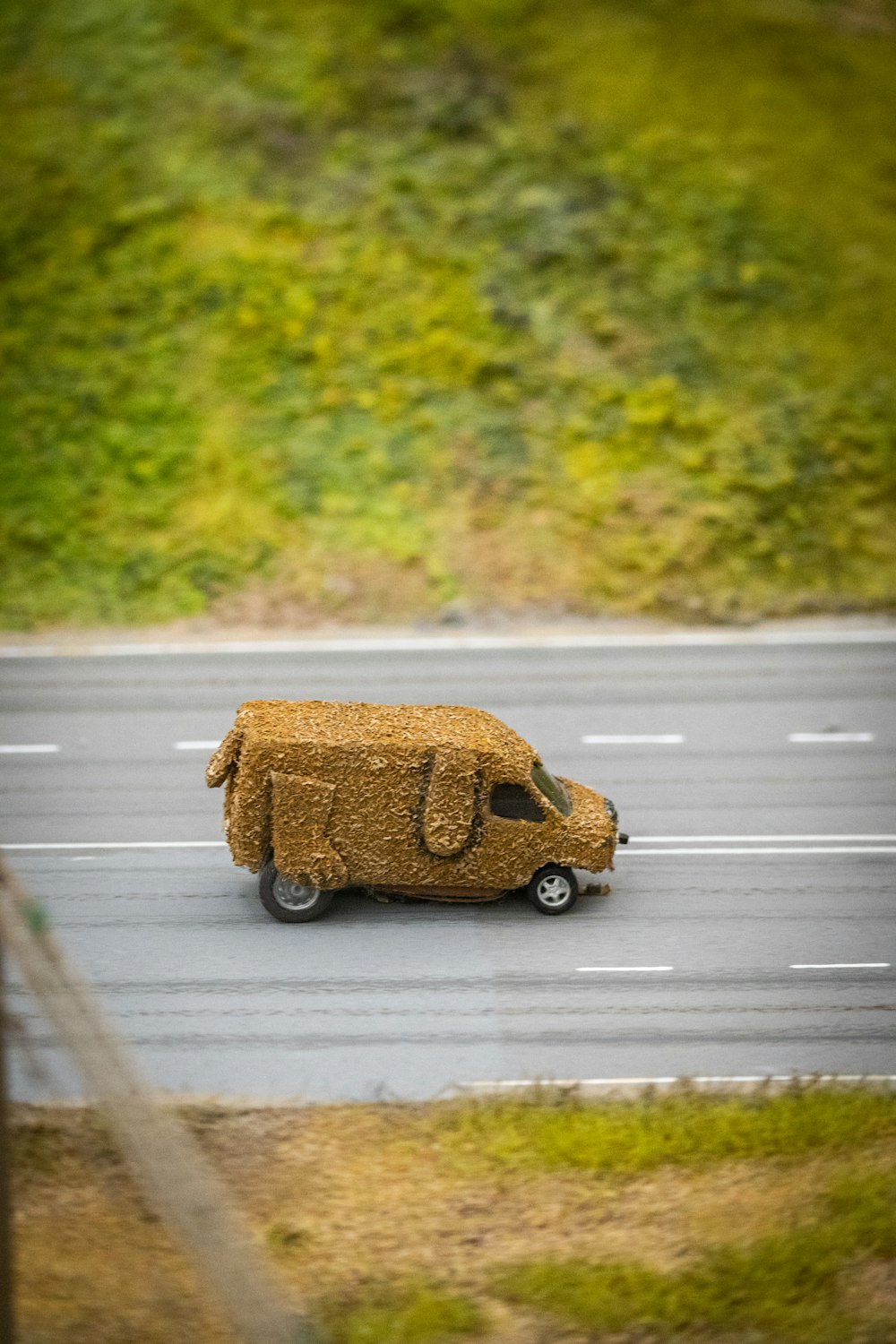 Un camión hecho de heno conduciendo por una carretera