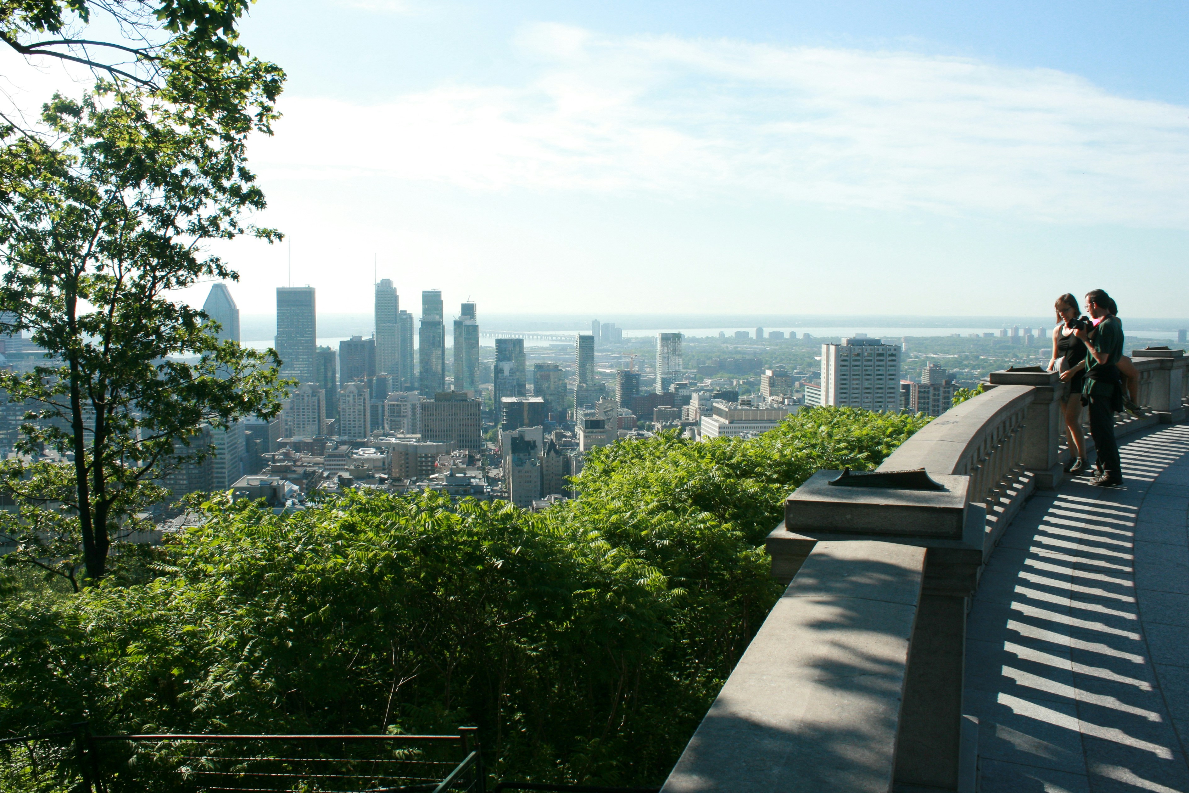 two people sitting on a bench overlooking a city