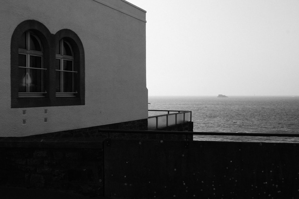 a black and white photo of a building near the ocean
