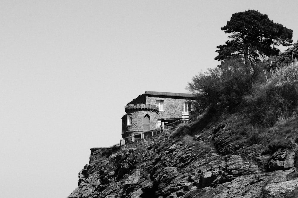 Una foto in bianco e nero di una casa su una scogliera