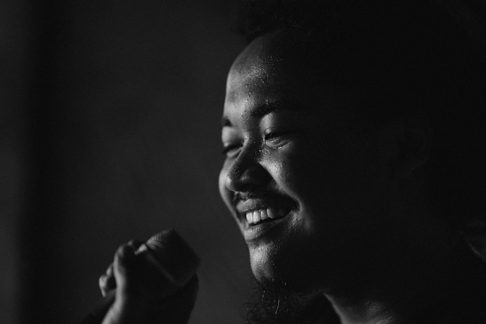 a black and white photo of a woman singing into a microphone