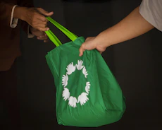 Close-up of hands exchanging recyclable goods with transparent pricing sheet.