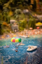 A vibrant scene of guests enjoying parasailing over Bali’s turquoise waters on a sunny day.