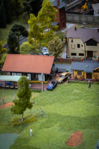 A detailed scenic diorama of a peaceful village with trees, houses, and tiny figures.