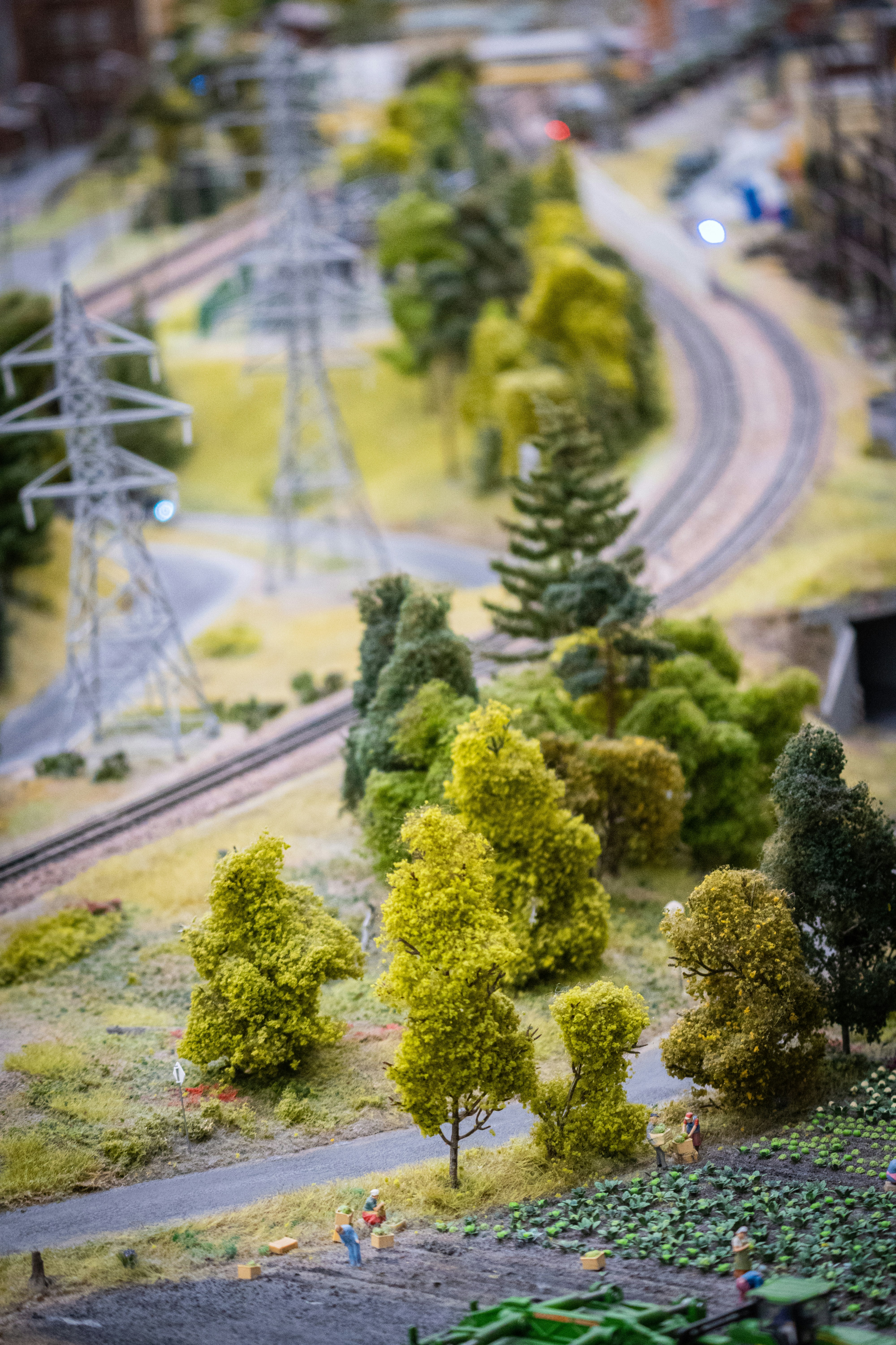 a model train track with trees and people on it