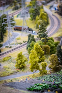 A close-up of a detailed N scale model train set winding through a miniature landscape with tiny trees and buildings.