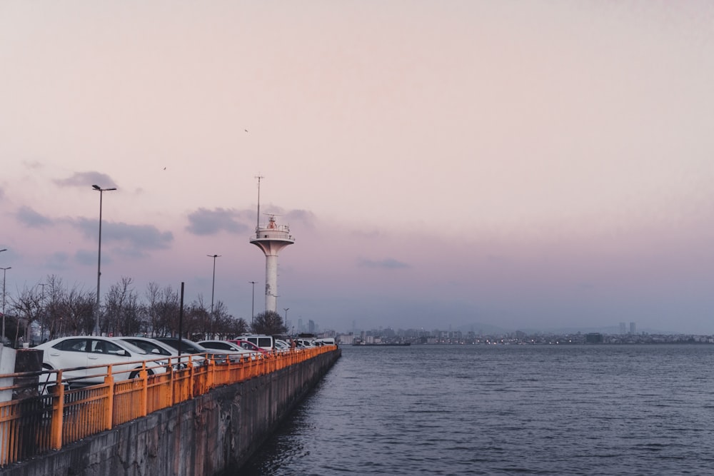 a row of parked cars next to a large body of water