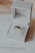 A luxurious ring with dark gemstones is elegantly presented in an open white jewelry box. The box rests on a card with branding and a diamond logo. The background is softly out of focus, enhancing the focus on the ring.