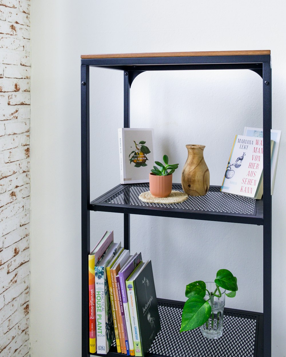 a shelf with books and a vase on top of it