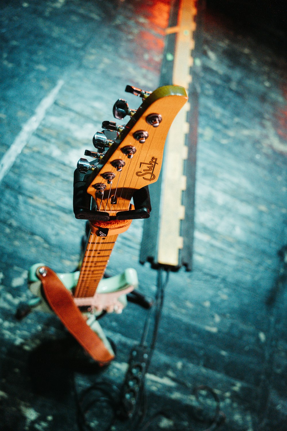 Una guitarra amarilla sentada encima de un soporte de madera