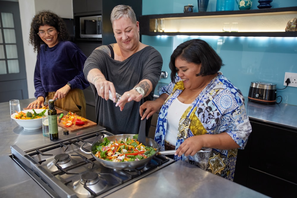 a man and two women preparing food in a kitchen