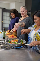 Happy participants sharing a meal they cooked together in a cozy Azerbaijani kitchen.