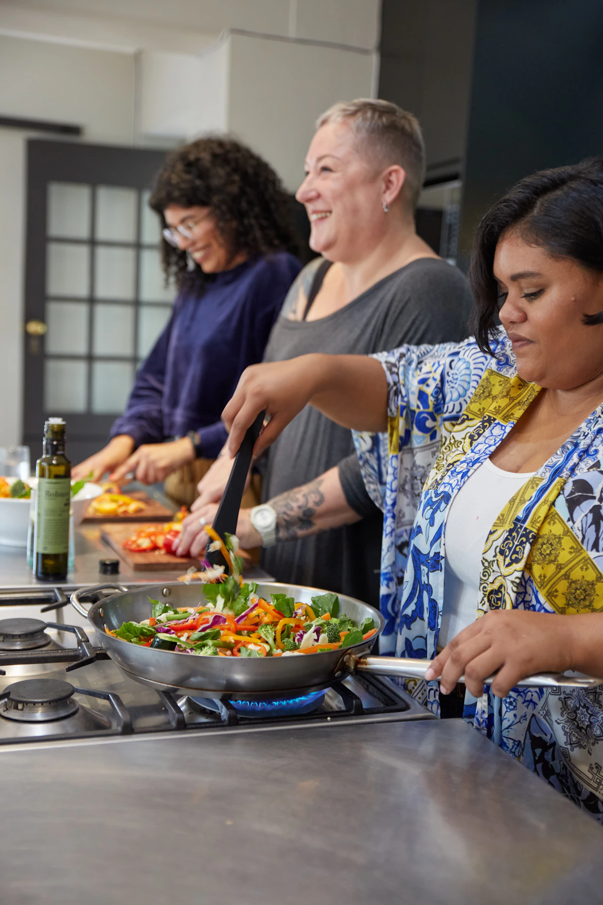Friends laughing while preparing a healthy meal
