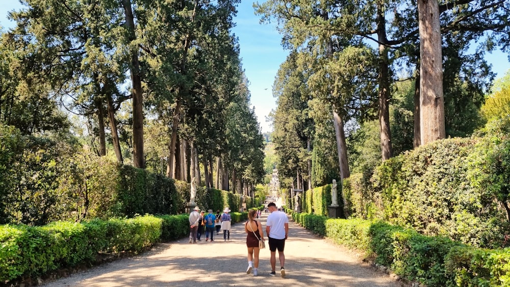 a group of people walking down a dirt road