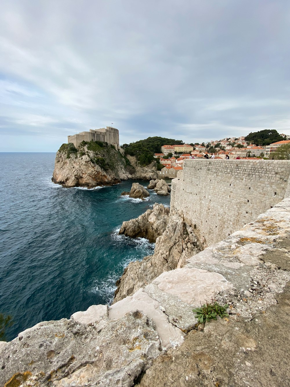 a large body of water next to a stone wall