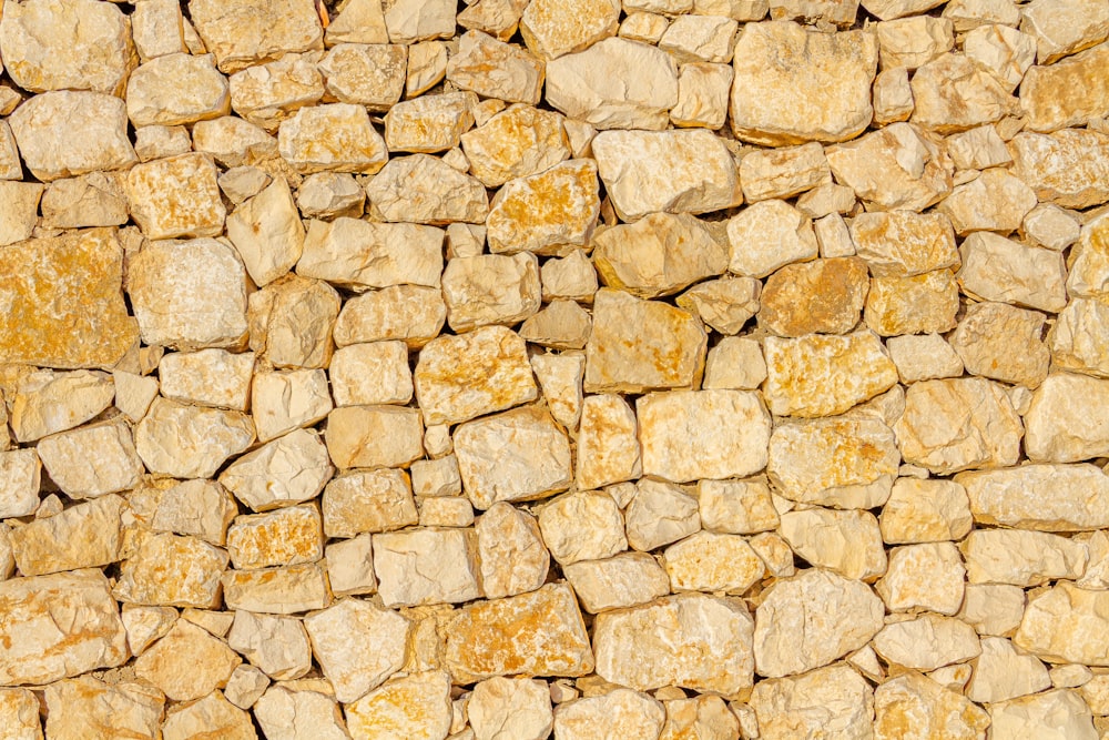 a stone wall made of yellow rocks