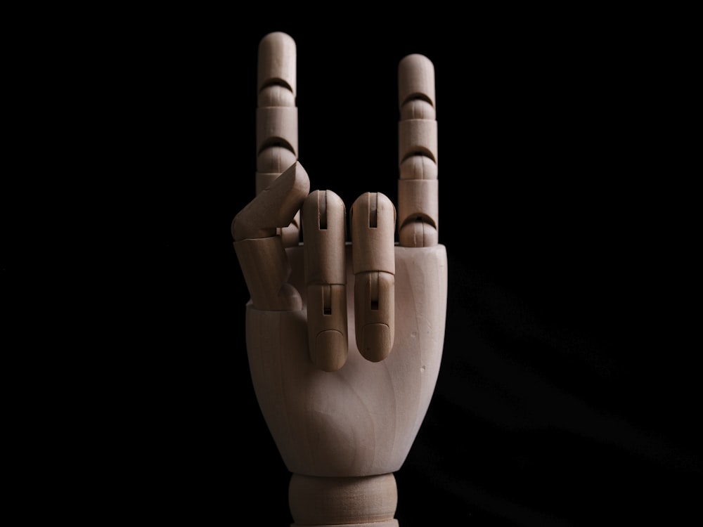 a wooden sculpture of a hand making a peace sign