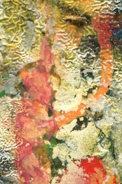 Close-up of a mixed media artwork featuring textures and deep colors.