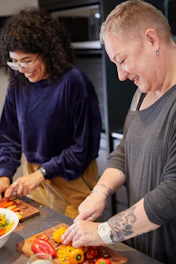 a man and a woman preparing food in a kitchen