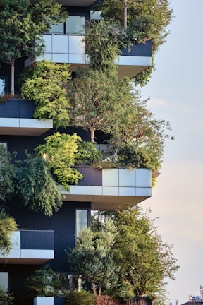 An apartment building featuring balconies lushly decorated with abundant greenery and trees, blending architecture and nature harmoniously.