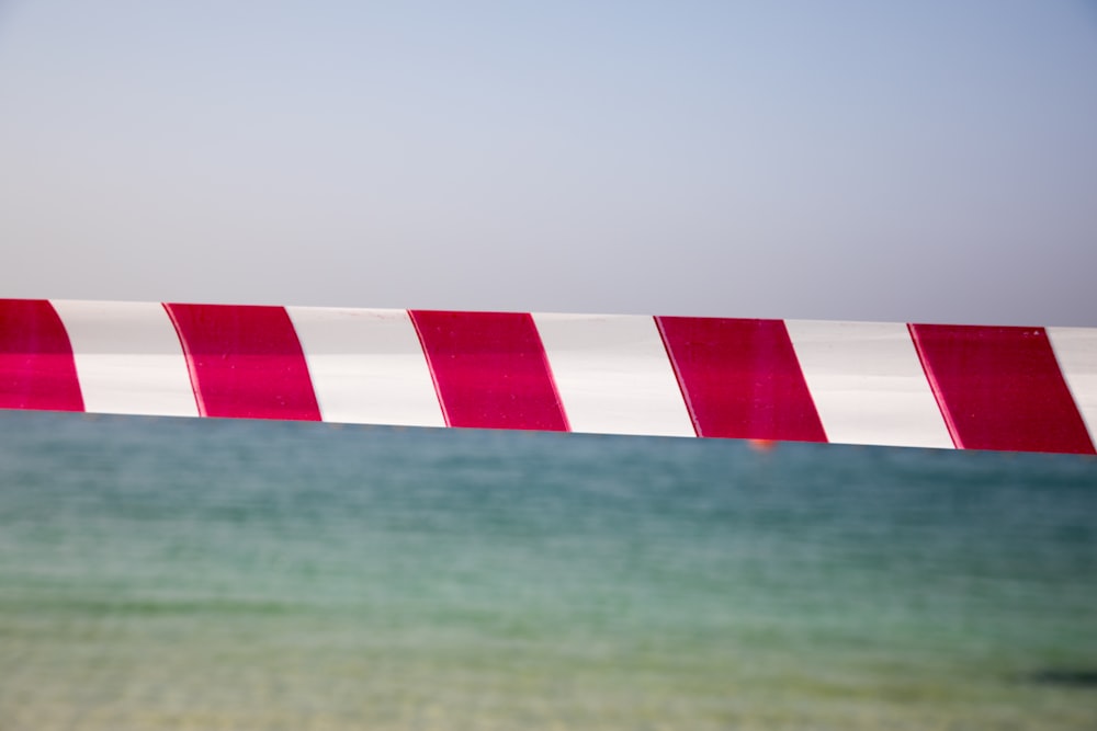 a red and white striped barricade over a body of water