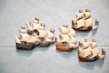 Colorful 3D printed keychains shaped like sailboats hanging on a wooden rack