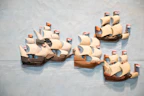 Colorful 3D printed keychains shaped like sailboats hanging on a wooden rack